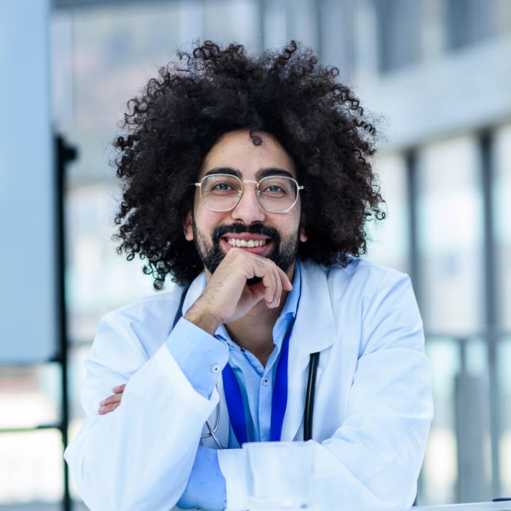 portrait-of-cheerful-male-doctor-sitting-in-hospit-2024-10-18-08-58.jpg